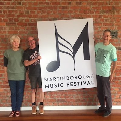 Marion Townend, Brendan Smyth and Andrew Morrison from the organising team holding up a sign with the 2020 logo on it