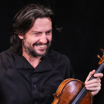 Chris Moore smiling and holding his viola