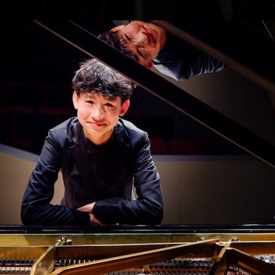 Shan Liu leaning over a piano